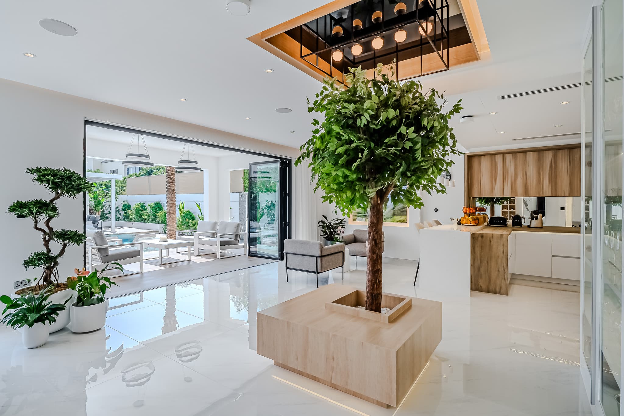 Luxury villa renovation in Jumeirah Park Dubai - open-plan living with indoor tree and pool view